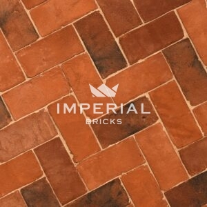 Tudor Multi pavers laid in the ground. The brick pavers are orange and red with some darker shades blended in.