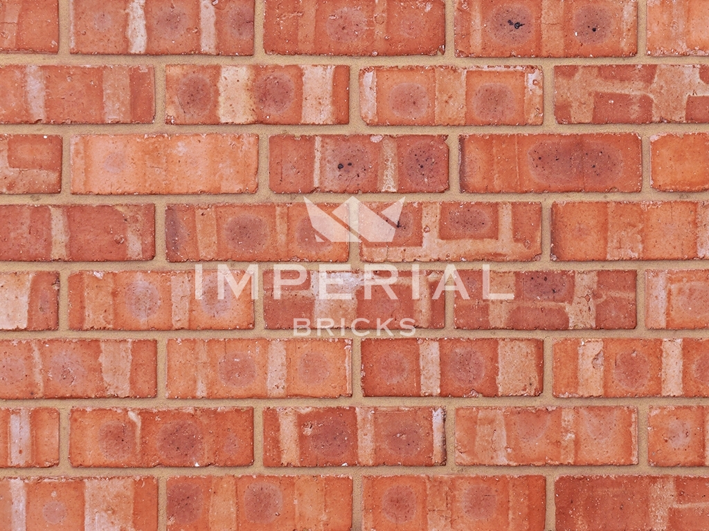 Cheshire Pre War extruded bricks shown in a wall. The bricks are an orange base colour with pale banding throughout.