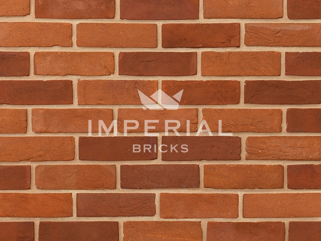 Camberley Blend handmade bricks shown in a wall. The bricks are an equal mix of orange and red colour shades.