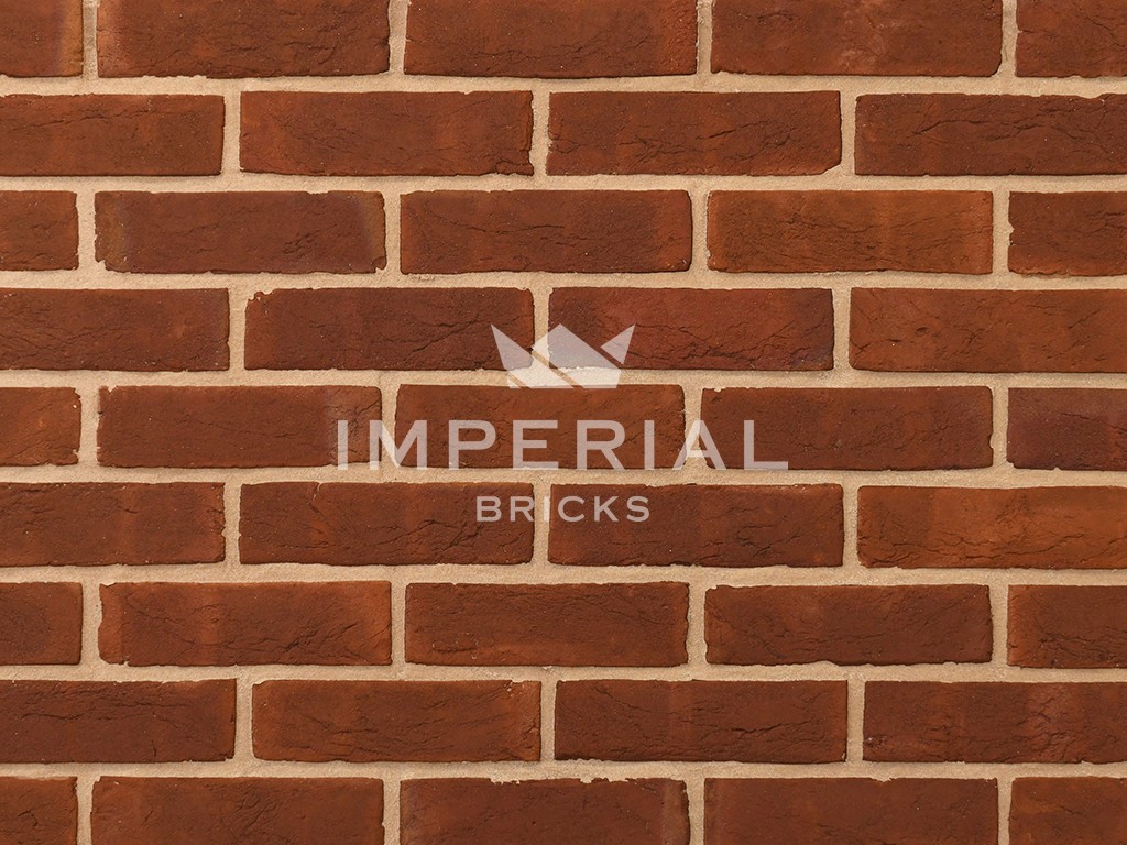 Georgian handmade bricks shown in a wall. The bricks are red, with orange and subtle plum tones.