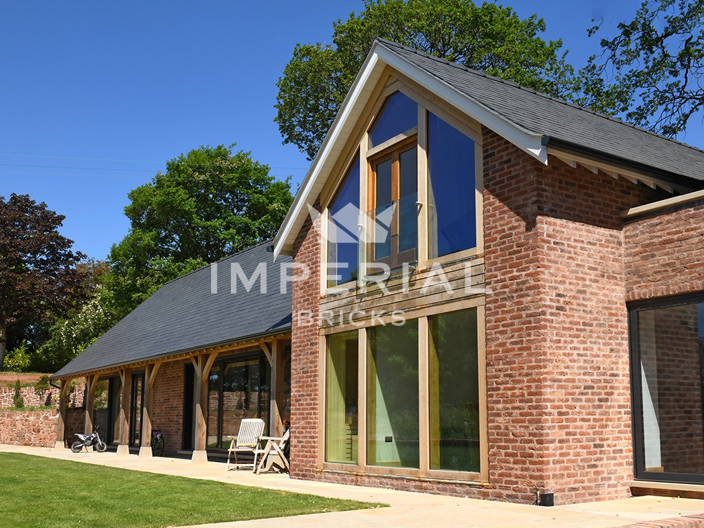 Large residential new build home built using Reclamation Cheshire handmade bricks. The bricks are complemented with a 2 storey oak frame and slate roof.