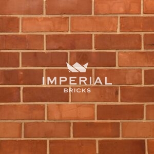 Reclamation Orange Wirecut bricks shown in a wall. The bricks are verying shades of orange with characterful chippings.