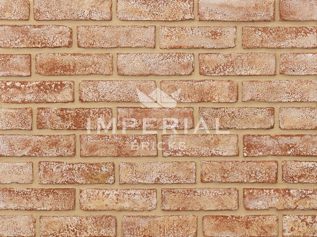 Victorian Limewashed Brick Tiles shown on a wall. The tiles are red with a heavy limewashed finish.
