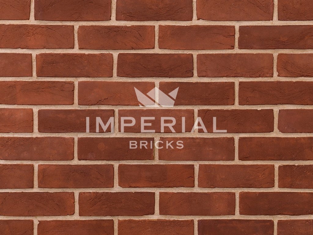 Weathered Soft Red bricks shown in wall. The bricks are textured with weathered faces.
