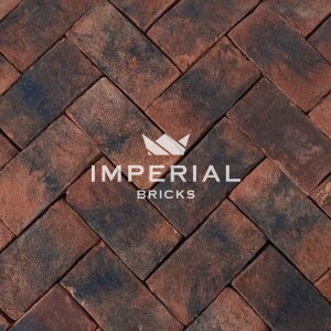Balmoral Blend pavers laid in the ground. The pavers are red with dark weathering and a sanded texture.