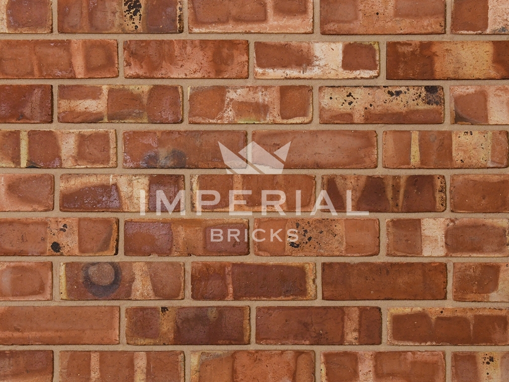 Pre War Common bricks shown in a wall. The bricks are red to orange colours with pale banding and dark overburns.