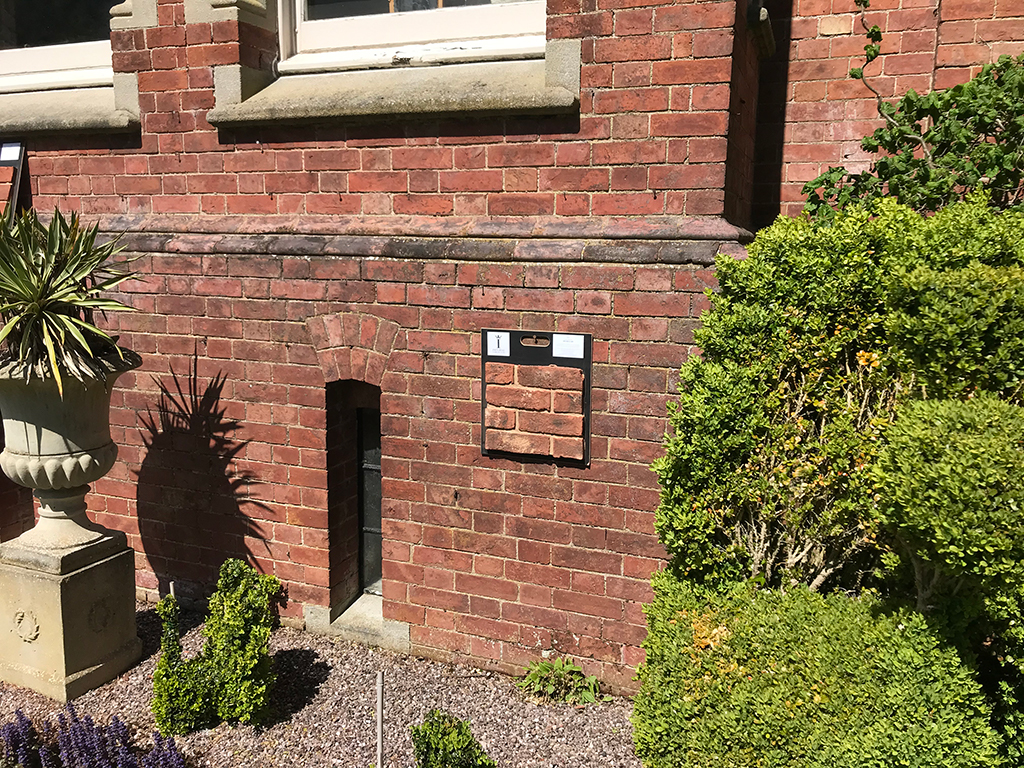 Wall showing brick match board and garden plants