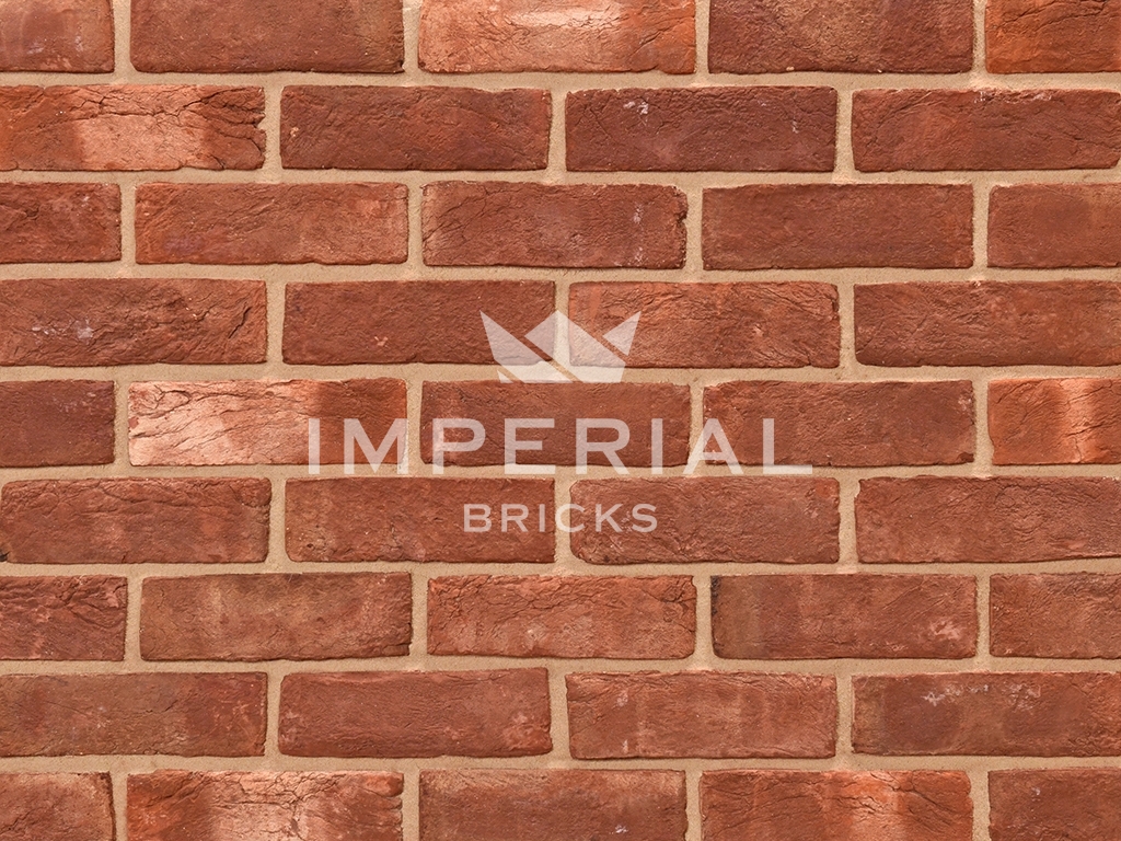 Red Handmade bricks shown in a wall. The bricks have a creased texture and pale banding.