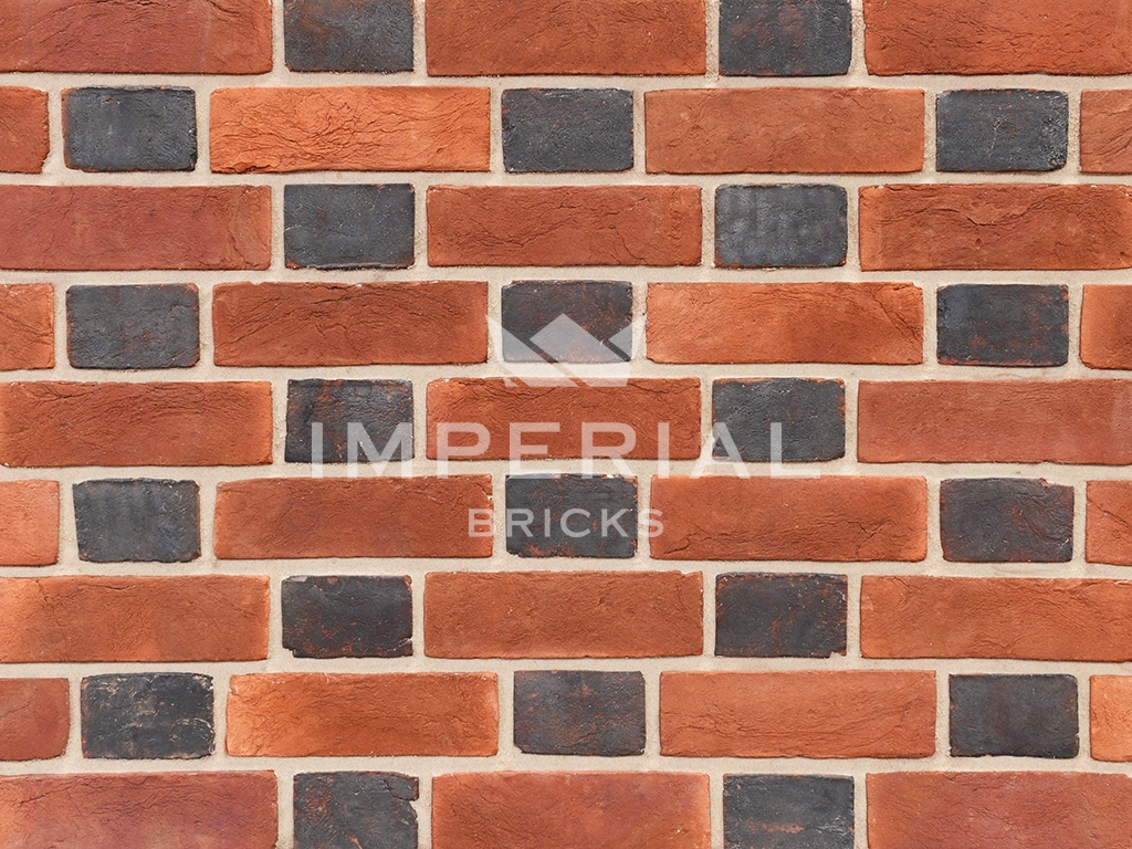 Blue header and soft red handmade bricks shown in a wall. The blue headers have a soft creased texture and are blue-grey in appearance.